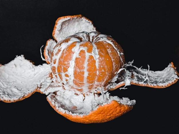 peeled tangerine with peel on black background