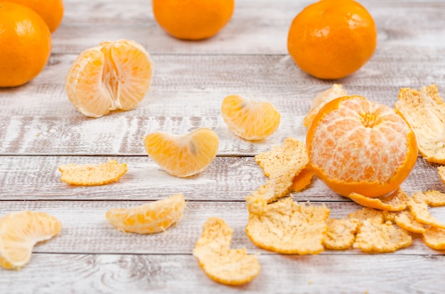 Peeled tangerines on wooden background