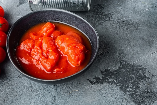 Peeled tomatoes, on gray background  with copy space for text