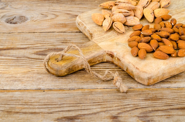 Peeled and unpeeled almonds on wooden table