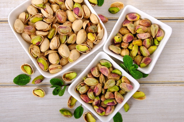 Peeled and unpeeled pistachios in square bowls 