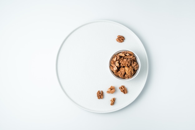 Peeled walnuts on a white surface