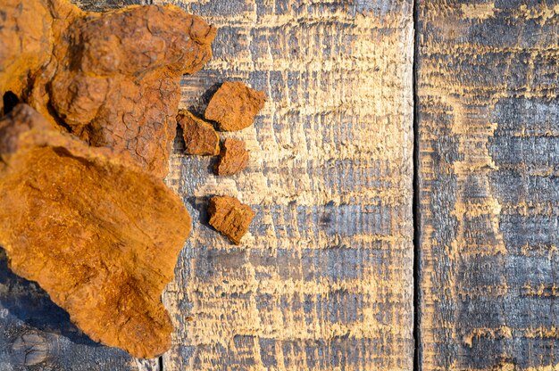 Peeled wild birch chaga mushroom on a wooden surface