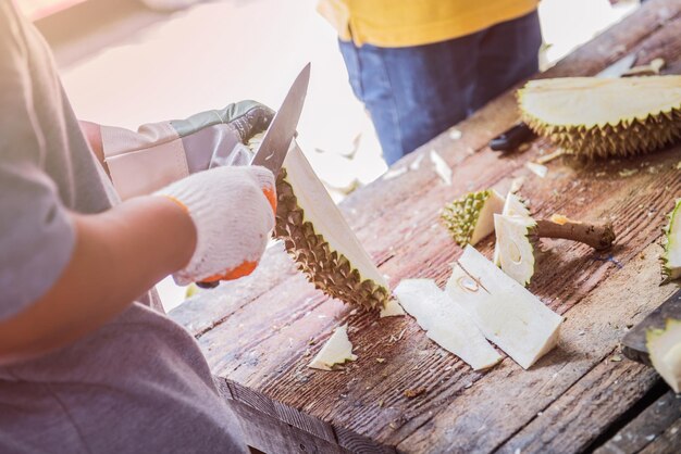 peeling durian by knife. Thai King fruit