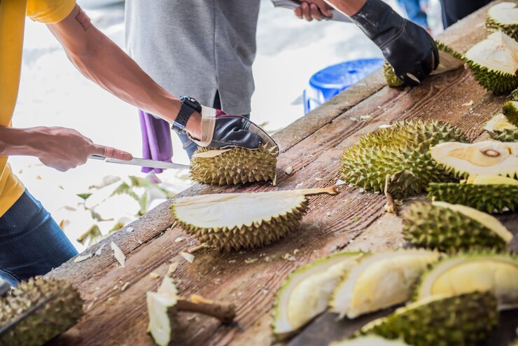 Photo peeling durian by knife. thai king fruit