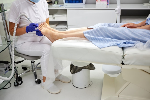 Peeling feet Pedicure SPA procedure in the beauty salon. Electric apparatus for pedicure. Woman getting her feet peeled in spa center