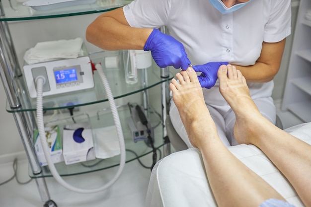 Peeling feet pedicure spa procedure in the beauty salon.\
electric apparatus for pedicure. woman getting her feet peeled in\
spa center