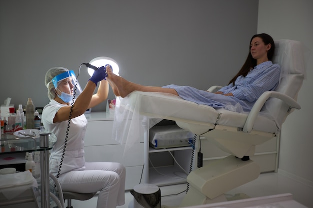 Peeling feet Pedicure SPA procedure in the beauty salon. Electric apparatus for pedicure. Woman getting her feet peeled in spa center