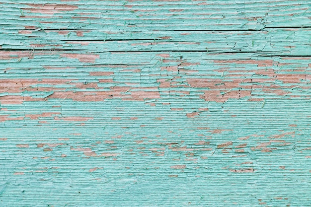 Peeling paint on light blue old wall. Rustic grunge background