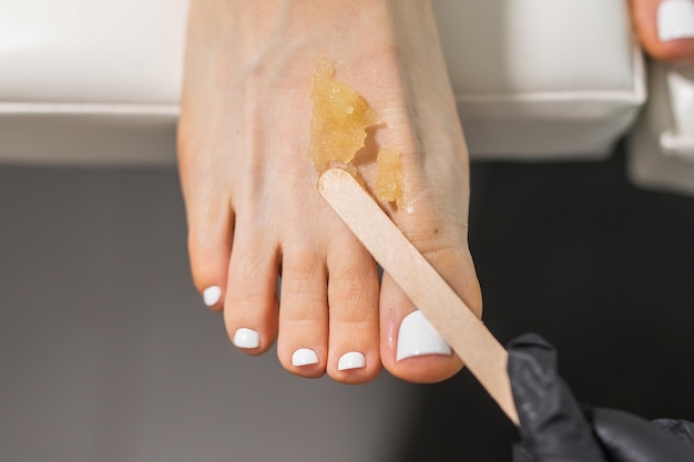 Peeling voeten pedicure procedure in een schoonheidssalon suiker scrub en ontspannen schoonheid procedure