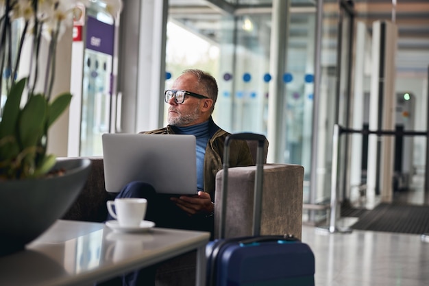 Peinzend mannetje met een gadget dat wegkijkt