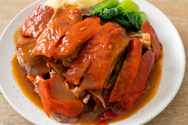 Photo peking duck or roasted duck in barbecue red sauce - chinese food style