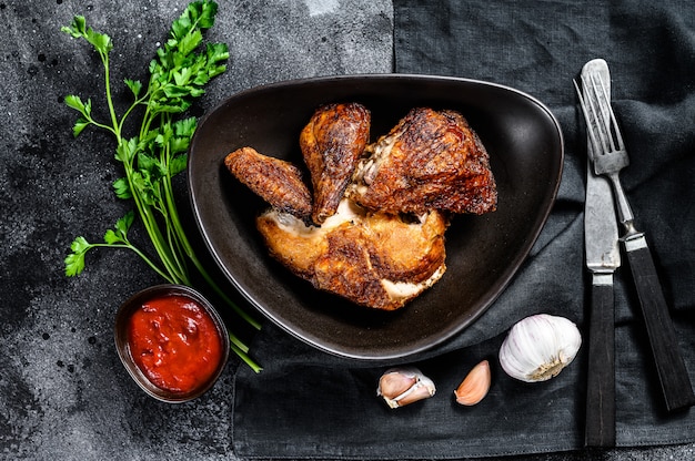 Peking style fried chicken. Black background. Top view