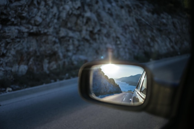 Photo peljesac reflecting on car side-view mirror