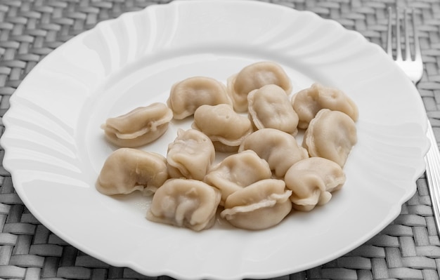 Pelmeni vlees dumplings op een witte plaat goede voeding gezonde voeding foto