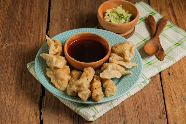 Pempek geserveerd op rustieke houten tafel. Pempek is traditioneel eten uit Indonesië. gemaakt van vis en tapioca geserveerd met rijke zoetzure saus of azijnsaus genaamd cuka