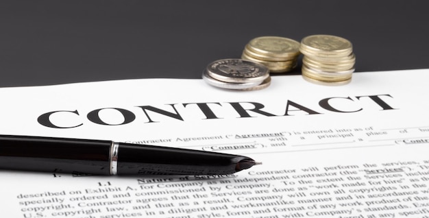 Фото Ручка и монеты на фирменном бланке контракта финансовая концепция