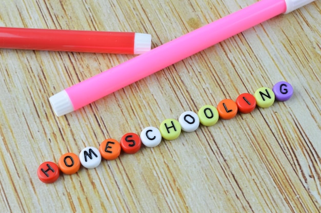 사진 텍스트 homeschooling 교육 개념이 있는 펜 색상 및 알파벳 구슬