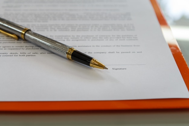 Photo a pen on contract paper preparation for signing a contract.