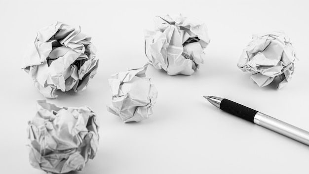 pen and crumpled paper ball on a white table. - work and business ideas concept.