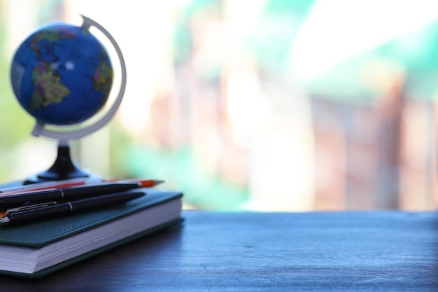 Photo a pen on the desk and a small blue globe