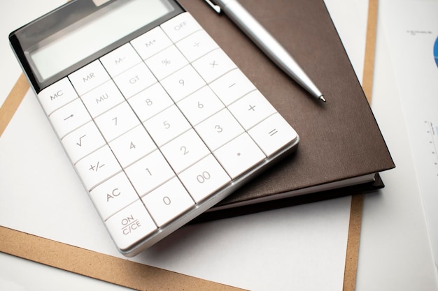 Foto pen en rekenmachine op grafiek financiën concept
