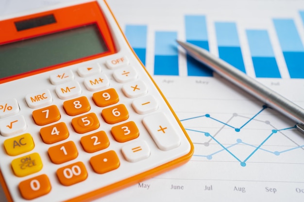 Pen en rekenmachine op grafiek of grafiekpapier Financiële rekeningstatistieken en bedrijfsgegevensconcept