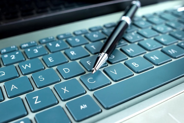 Foto una penna sulla tastiera di un portatile