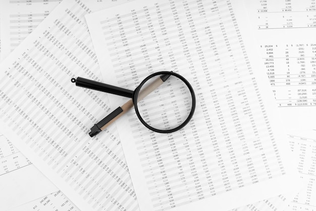 Pen and magnifying glass on financial statement