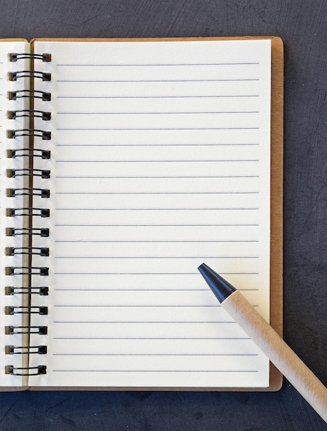 Pen and notebook on a black board