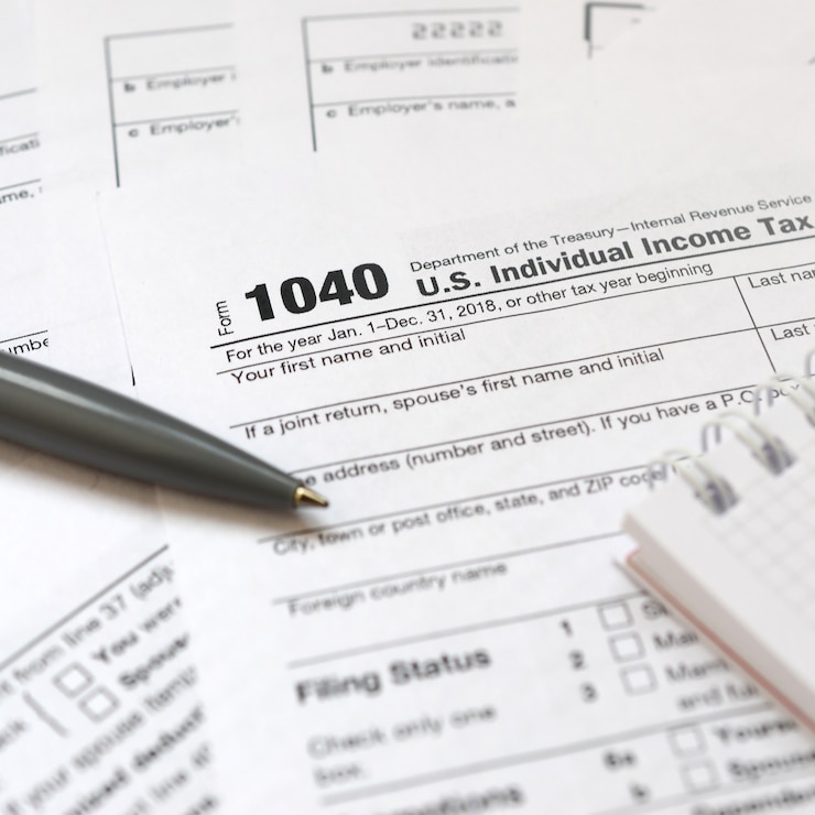 Photo the pen and notebook is lies on the tax form 1040 u.s. individual income tax return. the time to pay taxes