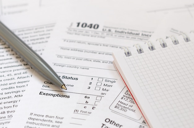 The pen and notebook is lies on the tax form 1040 U.S. 