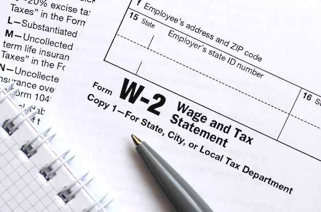 The pen and notebook on the tax form W2 Wage and Tax Statement The time to pay taxes