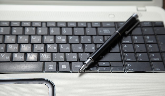 Photo pen and notepad on the computer keyboard