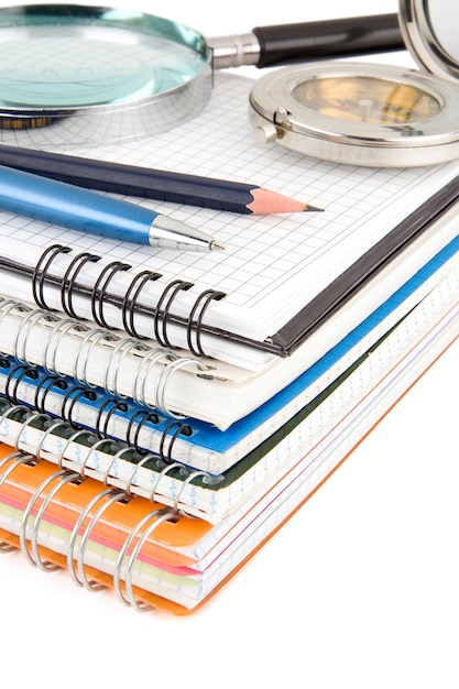 Pen and pencil at pile of notebook isolated