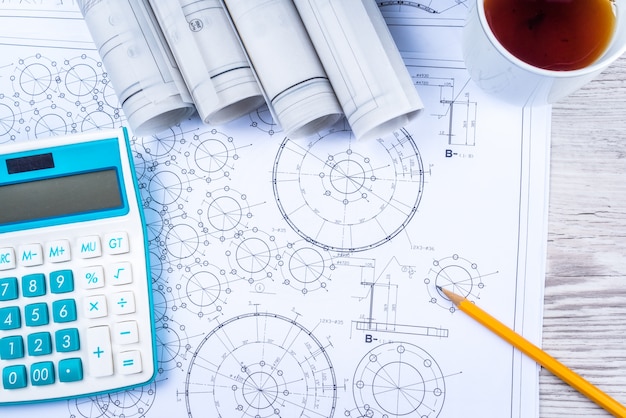 Pen, tea and calculator on paper table with diagram