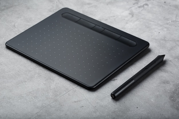 Pen with a graphic tablet in the hands of the designer, close-up. Gadget for art and work.