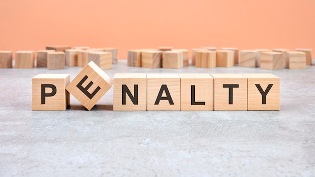 Слово PENALTY, написанное на деревянном блоке Текст содержимого на деревянном столе для вашей концепции дизайна