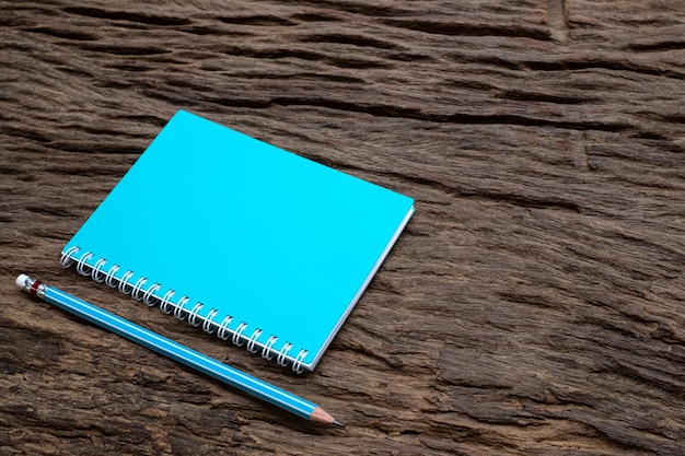 Foto mockup di matita e libro sulla vecchia scrivania in legno, vista dall'alto