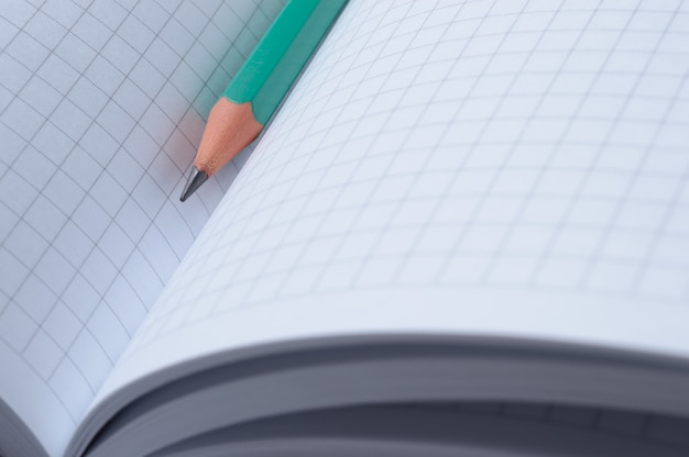 pencil lies on an open notebook. close-up.