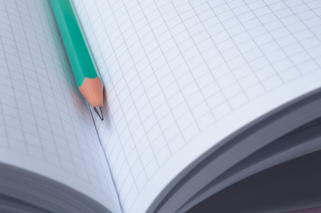 Photo pencil lies on an open notebook. close-up.