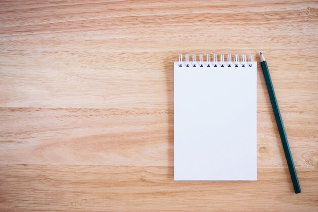 Pencil and Notepad on the wooden desk table