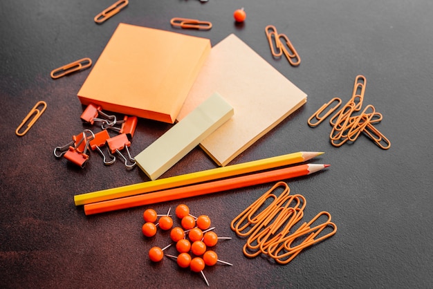 The pencil, paper clips and sheets for marks lie on a desktop