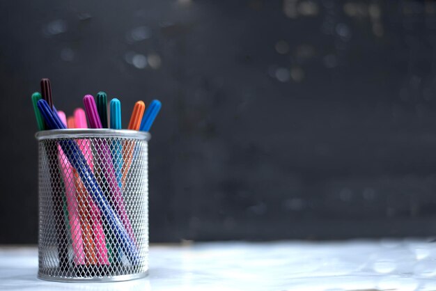 Photo pencil pen and crayons in a box blurred black background