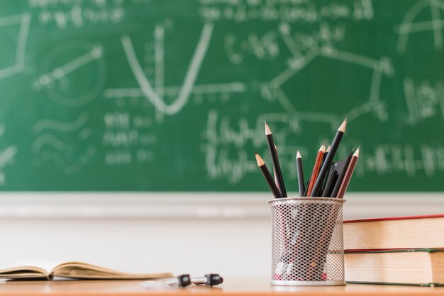 Pot di matita e libri sulla scrivania in classe di matematica