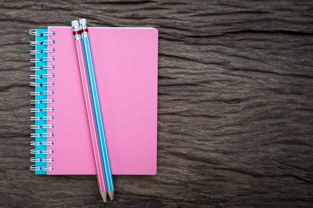 Pencil on top of book mockup on old wood desk