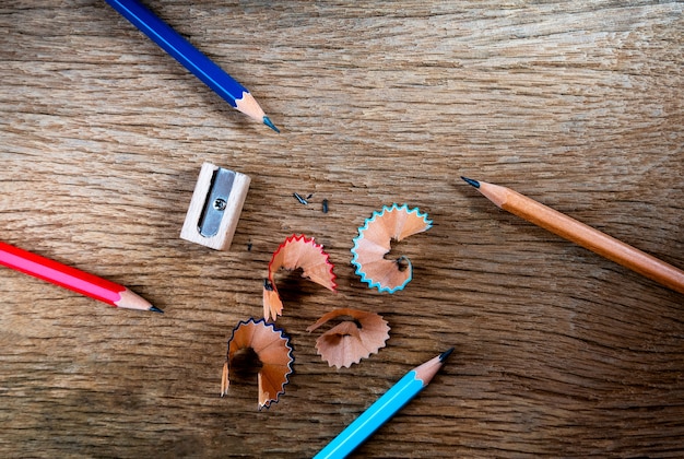 Pencil with sharpening shavings  on old wooden table background