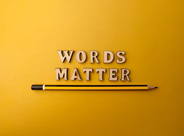 Pencil and wooden letter toy arranged the word WORDS MATTER