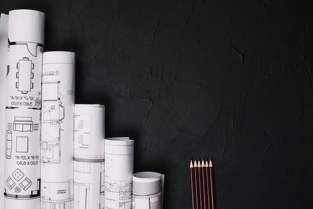 Pencils and blueprints on table