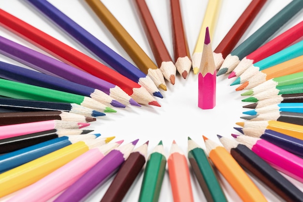 Pencils lined in the shape of a heart with an arrow on a white background